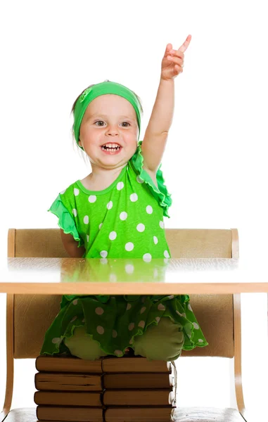 Mignonne petite fille assise à une table sur les livres — Photo