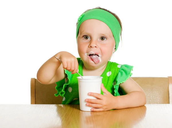 Girl eats with a spoon dairy product. — Stock Photo, Image