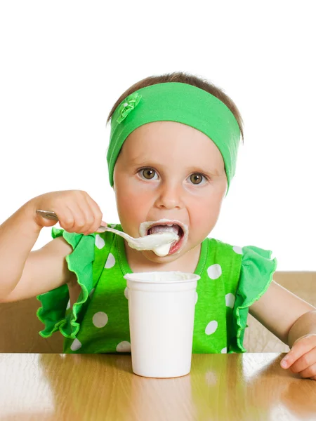 Girl eats with a spoon dairy product. — Stock Photo, Image