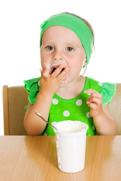 Girl eats with a spoon dairy product. — Stock Photo, Image