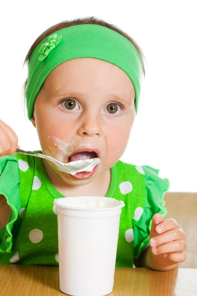 Fille mange avec une cuillère de produits laitiers . — Photo