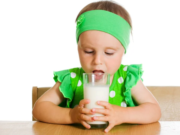 Cute little girl drinking milk from big glass — Stock Photo, Image