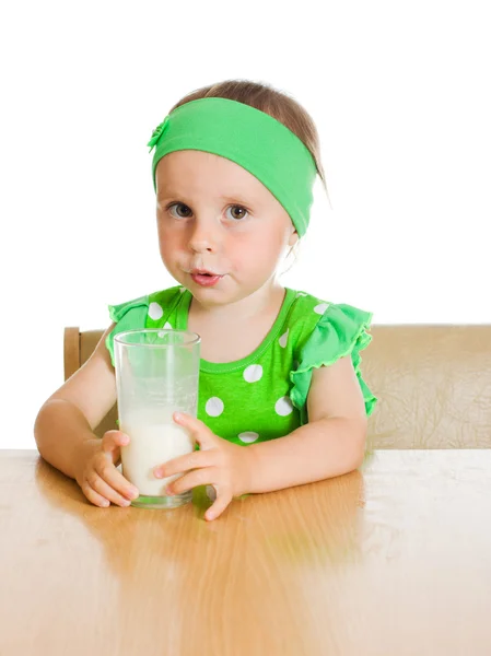 Cute little girl drinking milk from big glass — Stock Photo, Image