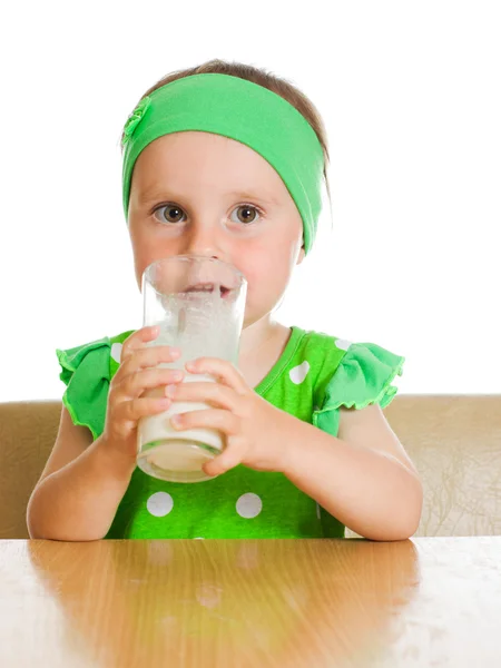 Roztomilá holčička pití mléka z velkých skla — Stock fotografie