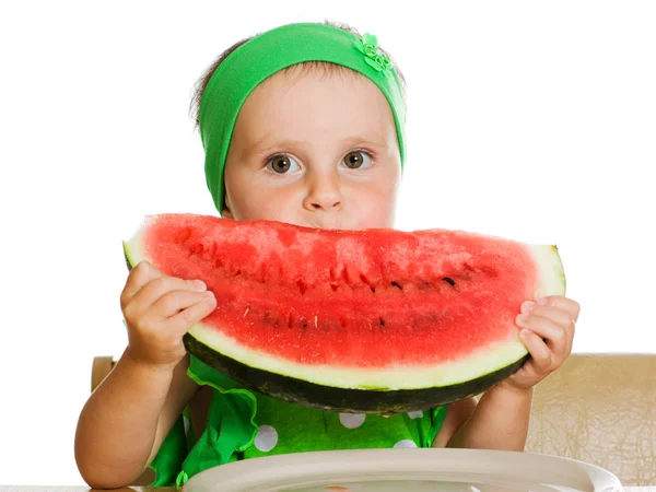 Little boy eating a watermelon at a table — Stock Photo, Image