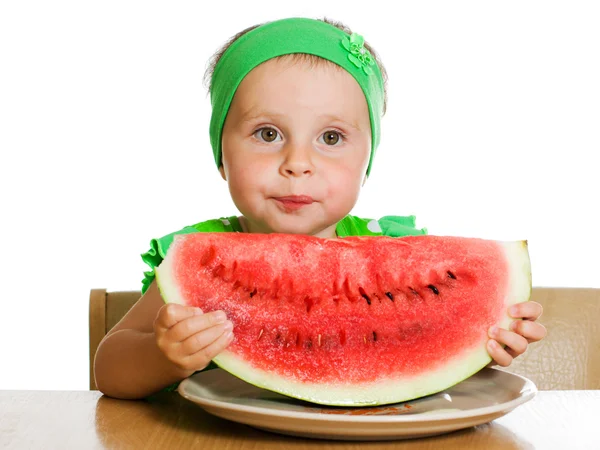 Little boy eating a watermelon at a table — Stock Photo, Image