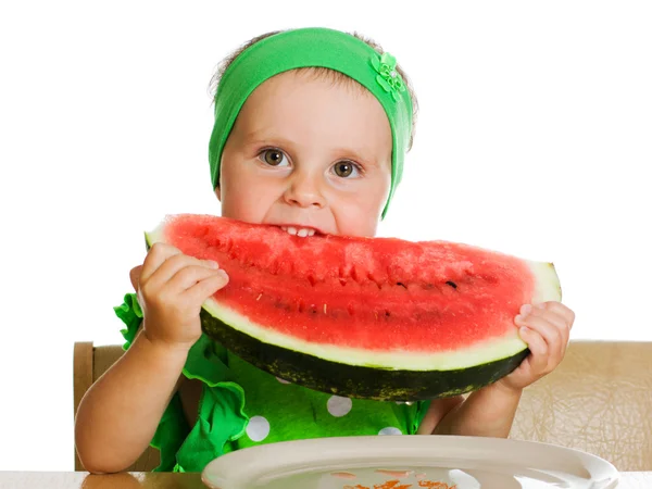 Menino comendo uma melancia em uma mesa — Fotografia de Stock