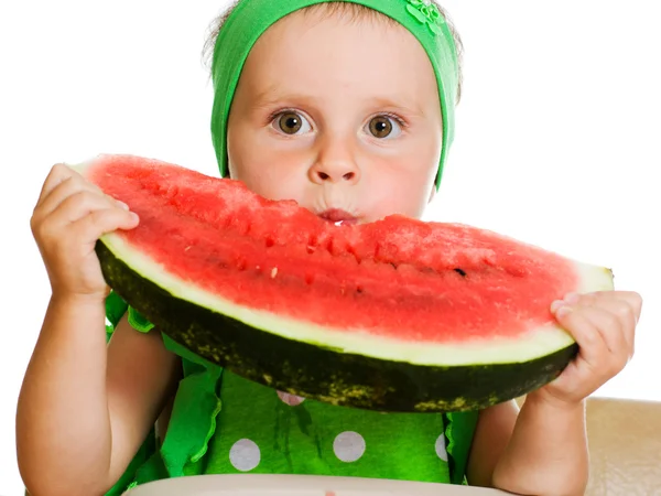 Little boy eating a watermelon at a table — Stock Photo, Image