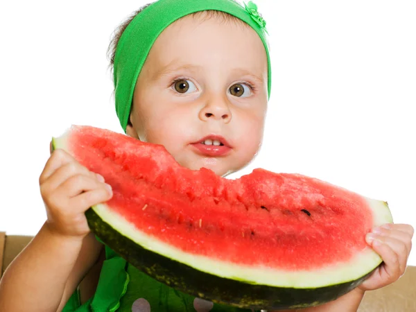 Little boy eating a watermelon at a table — Stock Photo, Image