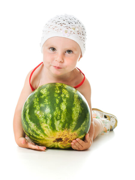 Очаровательный ребенок счастливо играет на арбузе.
