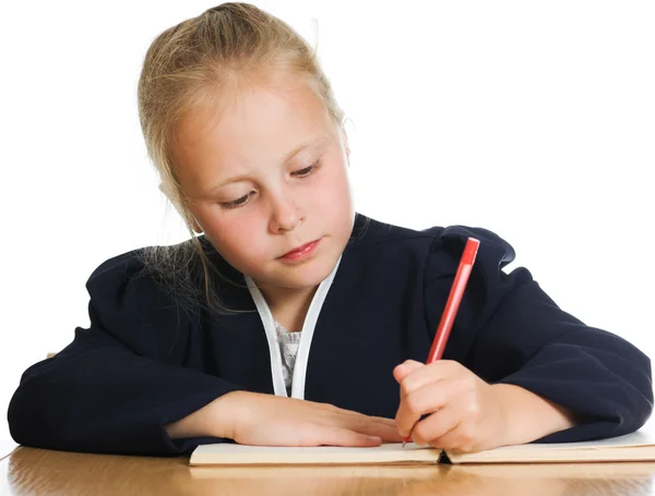 Schoolgirl пишет за столом — стоковое фото