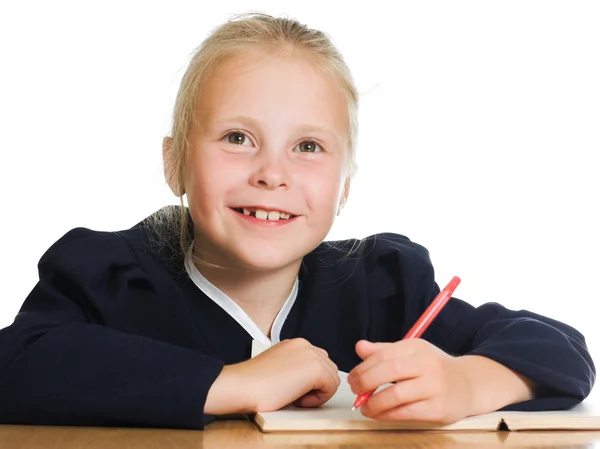 Schoolgirl writes at a table — Stock Photo, Image