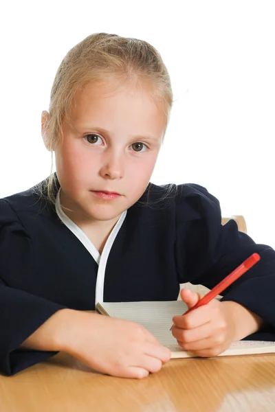 Schoolgirl writes at a table — Stock Photo, Image