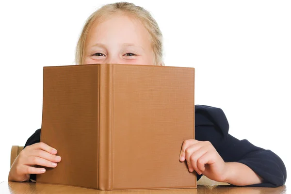 Skolflicka som gömmer sig bakom en bok — Stockfoto