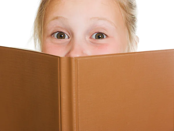 Schoolgirl is hiding behind a book — Stock Photo, Image