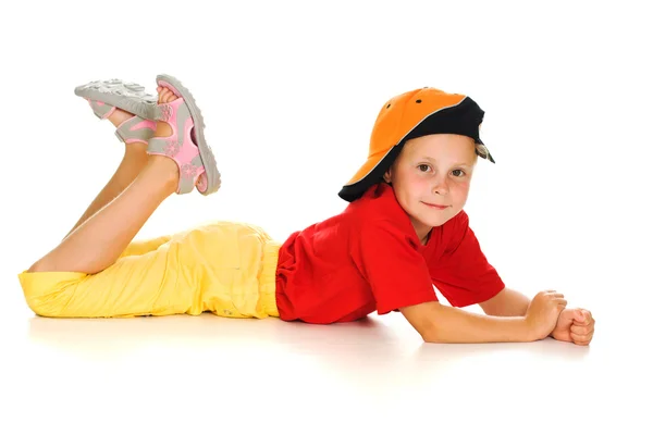 A cheerful little child with funny cap is lying — Stock Photo, Image