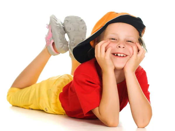 Un niño alegre con gorra divertida está mintiendo —  Fotos de Stock