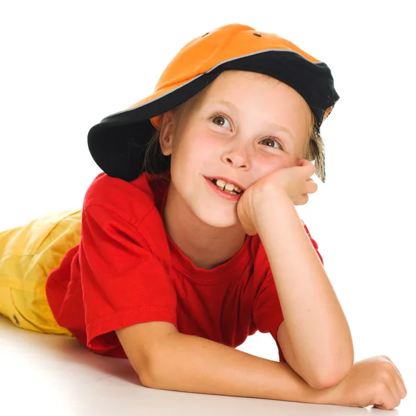 A cheerful little child with funny cap is lying — Stock Photo, Image