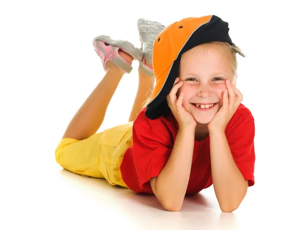 Uma criança alegre com boné engraçado está mentindo — Fotografia de Stock