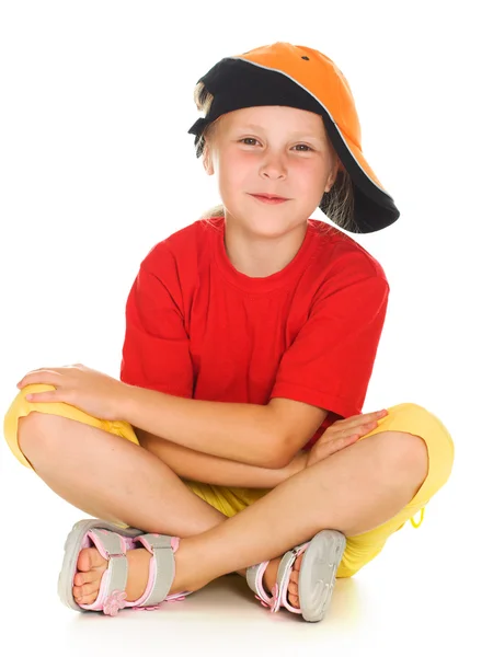 A cheerful little child with funny cap is sitting — Stock Photo, Image