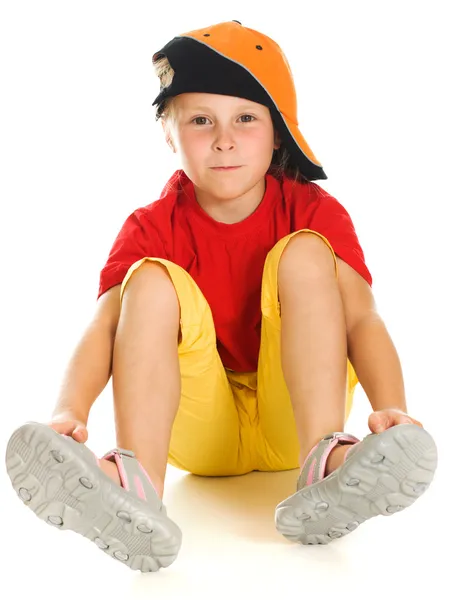 Un niño alegre con gorra divertida está sentado —  Fotos de Stock