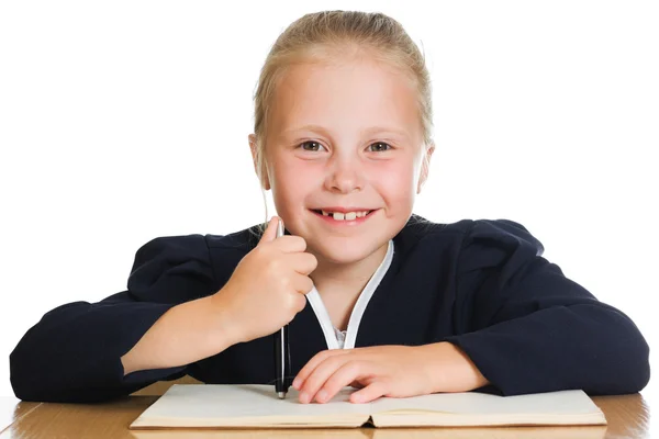 Schoolgirl writes at a table Stock Photo