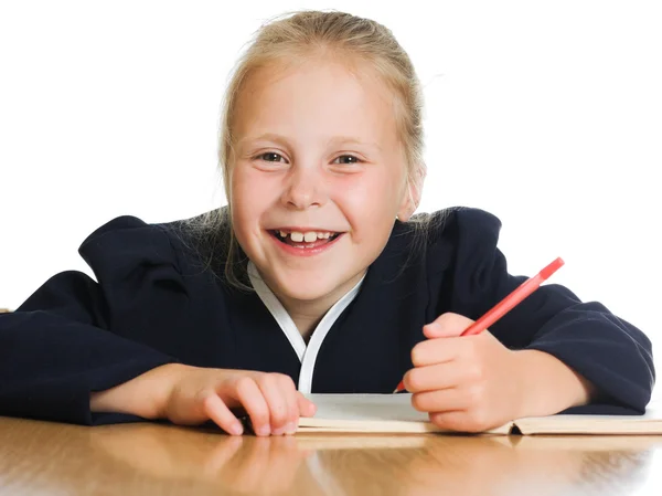 Schoolgirl writes at a table Royalty Free Stock Photos