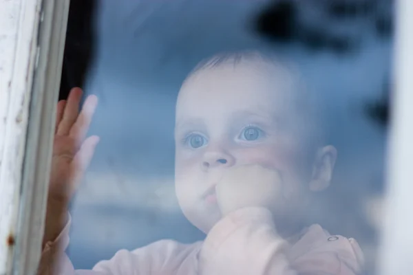 Jonge baby op zoek vanuit venster — Stockfoto