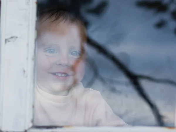 Jonge baby op zoek vanuit venster — Stockfoto