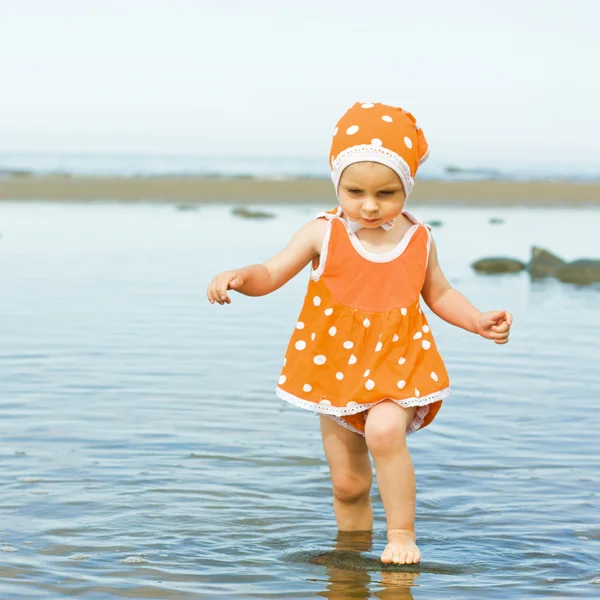 Little baby girl walking on the water — Stock Photo, Image