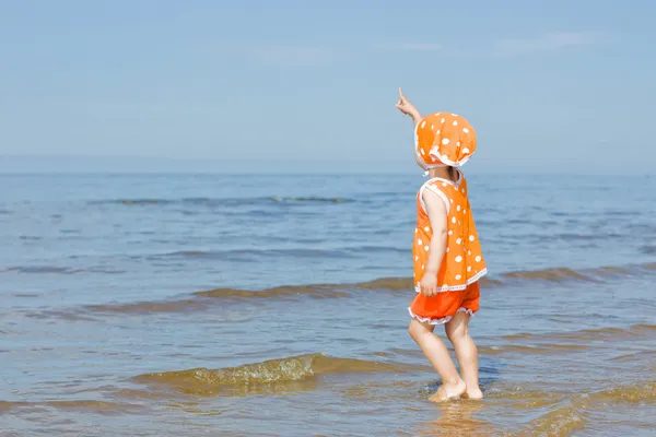 Babymeisje lopen op het water — Stockfoto