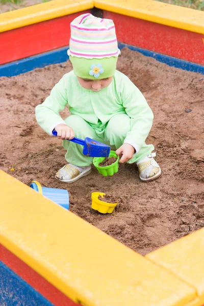 Niño jugando en una caja de arena — Foto de Stock