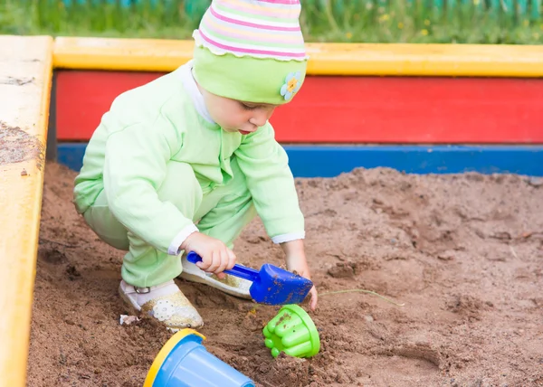 Niño jugando en una caja de arena — Foto de Stock