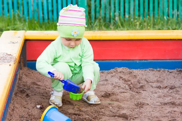 Niño jugando en una caja de arena — Foto de Stock