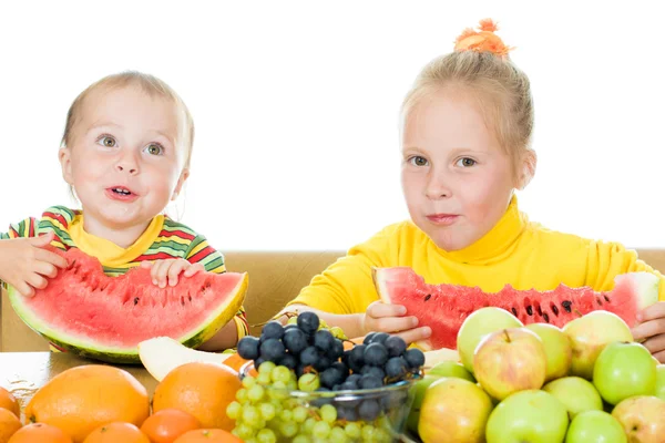 Dwoje dzieci jeść owoce na stole — Zdjęcie stockowe