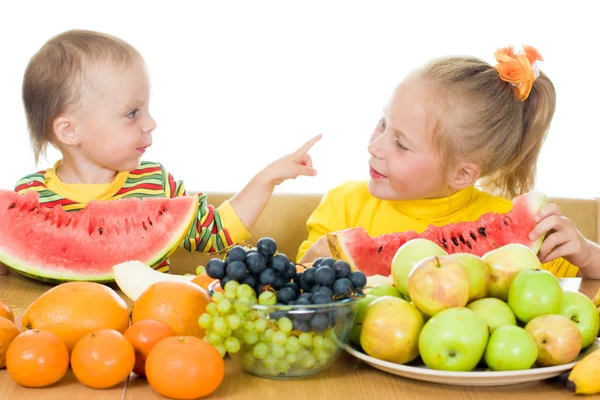 Iki çocuk, bir masada meyve yiyin. — Stok fotoğraf