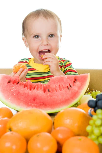 Дитина їсть фрукти на білому тлі — стокове фото