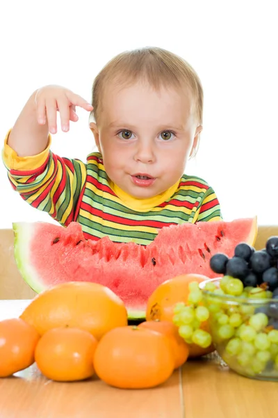 Bebê come frutas em um fundo branco — Fotografia de Stock