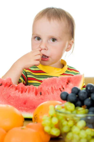 Bebê come frutas em um fundo branco — Fotografia de Stock