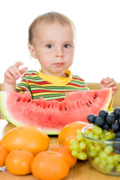 Bebê come frutas em um fundo branco — Fotografia de Stock