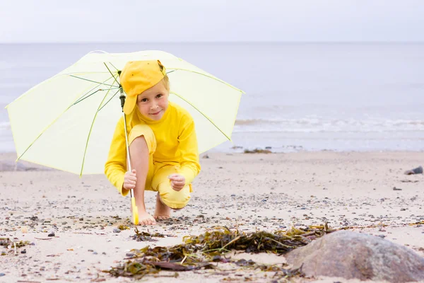 Chica con paraguas en una playa — Foto de Stock