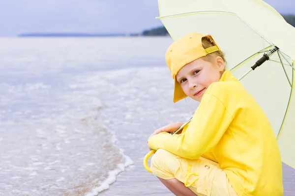 Chica con paraguas en una playa — Foto de Stock