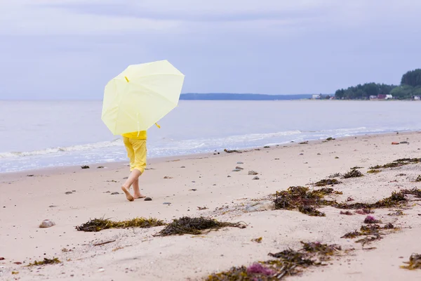 Menina com guarda-chuva em uma praia — Fotografia de Stock