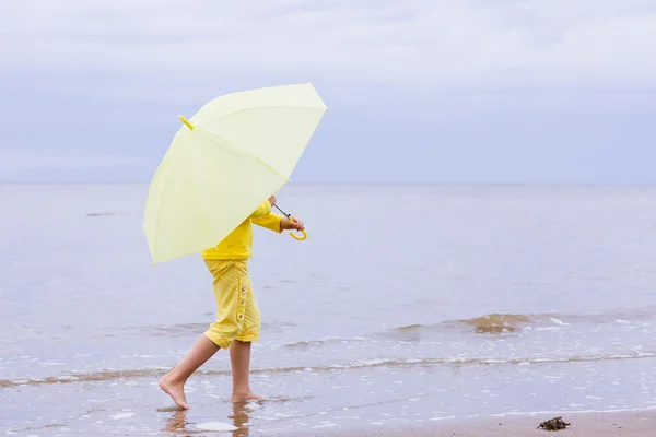 Girl with umbrella on a beach — Stock Photo, Image