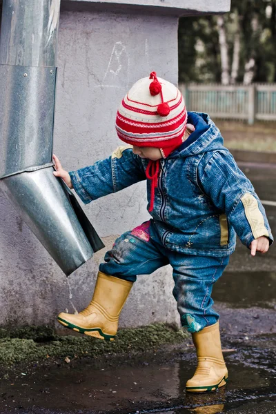 Baby washes the feet of a drain pipe. — Stock Photo, Image