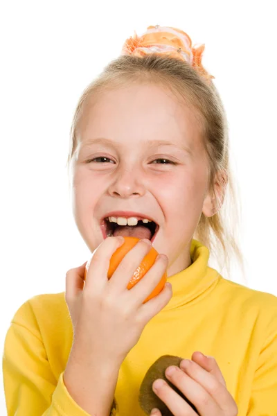 Söt flicka biter en orange — Stockfoto