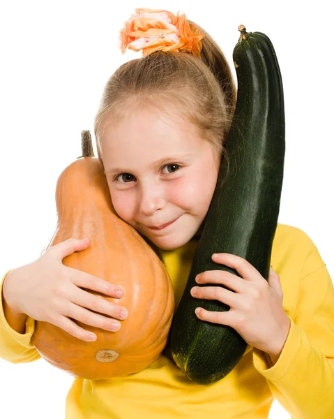Cheerful girl holding a pumpkin and squash — Stock Photo, Image