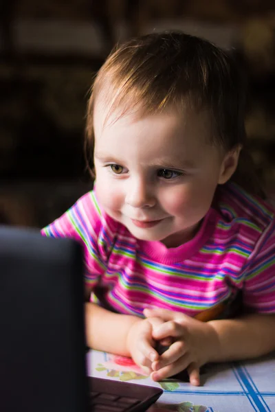 Miúdo bonito com um laptop . — Fotografia de Stock