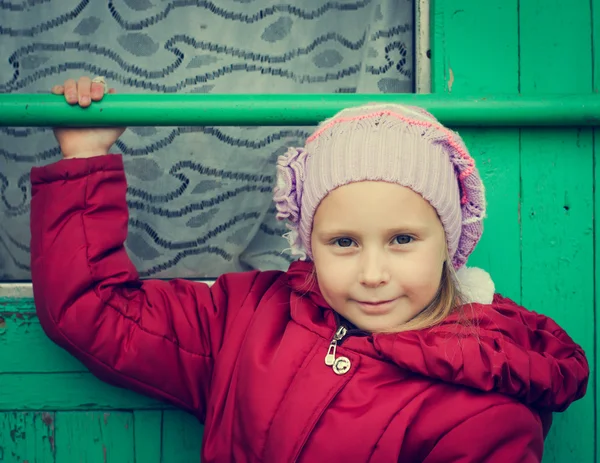 Mooi meisje in een rode jas — Stockfoto