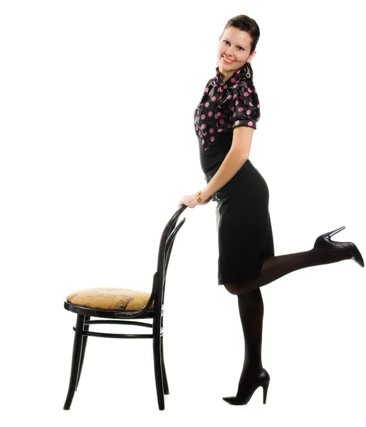 Αρκετά χαρούμενος ρετρό γυναίκα να στέκεται με μια καρέκλα. — Φωτογραφία Αρχείου